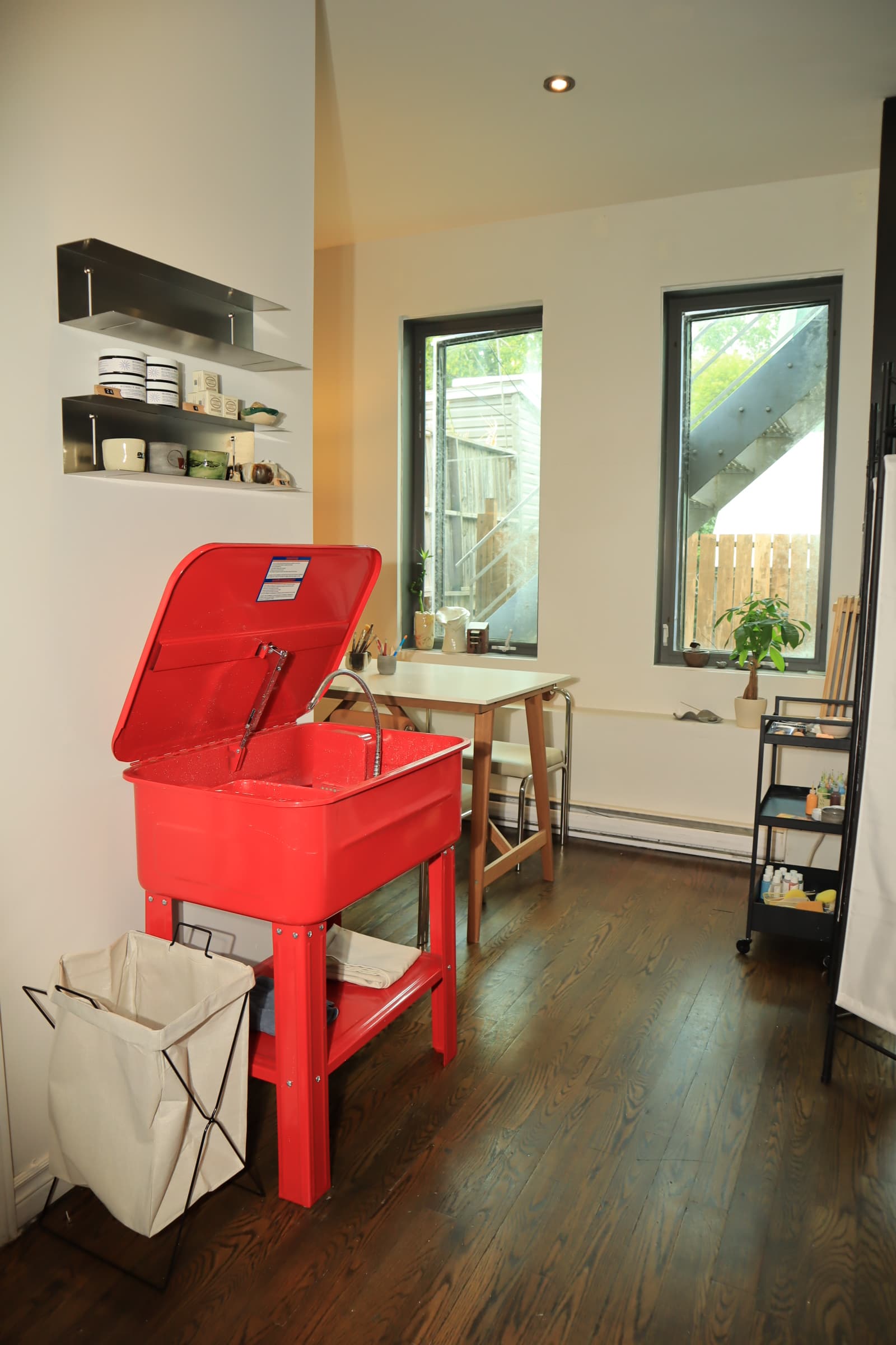 The SAH pottery studio with its red wash station, worktable, and sunlit windows